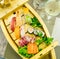 Exquisite wooden boat filled with different types of sushi and fish pieces