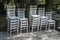 Exquisite wooden white chairs one on the other in garden