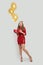 Exsited surprised woman with red gift and yellow balloons standing on white background