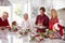 Extended Family Group Preparing Christmas Meal In Kitchen