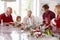 Extended Family Group Preparing Christmas Meal In Kitchen