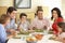 Extended Hispanic Family Enjoying Meal At Home