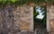 Exterior of ancient ruined stone building. Old abandoned house with empty entrance and grass. Ruined brick house with door.