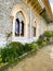 Exterior architectural details of a mansion lined with flowers and plants