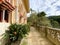 Exterior architectural details of a mansion lined with flowers and plants