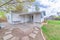 Exterior of a back of a house with sliding glass door and white vinyl wood siding