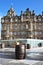 Exterior of Balmoral Hotel in Edinburgh with famous clock, Scottish flag. Whisky barrel in foreground.