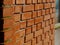 Exterior brown clay brick wall corner with weathered cement joints