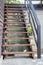 Exterior brown wooden staircase with iron banister