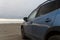 Exterior details of blue hatchback at sand beach in dusk light