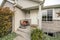 Exterior of an entrance of a house with white front door and rocking bench with pillows