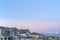 Exterior of homes and mountain with snowy peak against cloudy blue sky at sunset