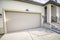 Exterior of a house with closed garage door and part of a porch entry with stairs