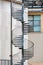 Exterior metal spiral fire escape staircase at the rear of a building