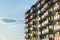 Exterior of modern residential apartment building with balconies on housing estate. Urban landscape with block of flats.