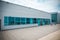 Exterior of a modern steel and green glass office building with empty walkway. panoramic and perspective view. Abstract