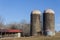 Exterior of old grain silos by modern animal stalls with solar panels, winter