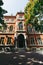 exterior of an old three story red brick building with white columns on entrance, beautiful stone windows surround, keystones and