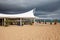 Exterior restaurant hotel dining area with white wooden furniture and palm tree with natural landscape view of ocean sea