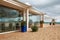 Exterior restaurant hotel dining area with white wooden furniture and palm tree with natural landscape view of ocean sea