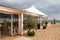 Exterior restaurant hotel dining area with white wooden furniture and palm tree with natural landscape view of ocean sea