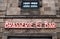 Exterior shot of Brasserie and Bar neon sign on an old stone wall