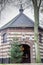 Exterior view of the Chapel of Mary in de Nood on a small hill with its gray dome, a Christmas tree next to the door