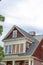 Exterior view of home with dormers and front porch framed by square columns