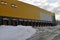Exterior view of a large warehouse in winter. Driveways