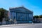 Exterior view of the main facade of the French National Assembly with netting covering the restauration scaffolding