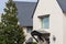 Exterior view of a slate roof residential house with a large magnolia tree