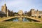 Exterior of the Wedding venue Ford Dining Hall at Berry College with a lake under blue sky