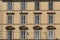 Exterior yellow wall of old building with windows and shutters