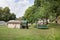 Exteriors of a small rural house with a trampoline, green lawn and trees around