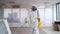 Exterminator in overalls and a protective mask with a sprayer