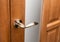 External door handle without protective lock on wooden frame.