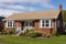 external view of a brick cape cod house with a side gable roof