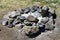 Extinct camp fire place with ashes surrounded with rocks or stones, photo of nature