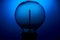 Extinguished electric vintage Edison light bulb with a spiral on a blue background. Retro style lamp