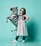 Extra cool asian baby girl kid in high fashion dress and sunglasses poses with zebra metallic balloon and makes a kissy face