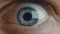 Extra macro shot of man`s opening eye with blue iris and big pupil resizing when exposed to light. Healthy eyesight and