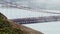 Extra telephoto view of traffic crossing Golden Gate with disturbance from mist