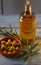 Extra virgin olive oil in a glass bottle, and a enameled clay pot with olives and an olive branch