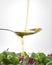 Extra virgin olive oil over tasty salad through spoon