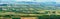 Extra wide panorama of small green fields as a quilt