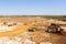 Extraction of sand in the quarry. Backhoe loading sand into dump trucks.