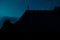 Extraterrestrial silhouette standing on roof during night time