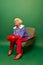 Extravagant accessories. Beautiful old woman, grandmother in stylish colorful clothes sitting on armchair over green