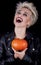 Extravagant blonde with a frightening grin with a pumpkin in the