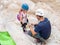 Extreme athlete preparing young atlete to descending with equipment for rappel in mountains of Judean Desert, near Rahaf stream,